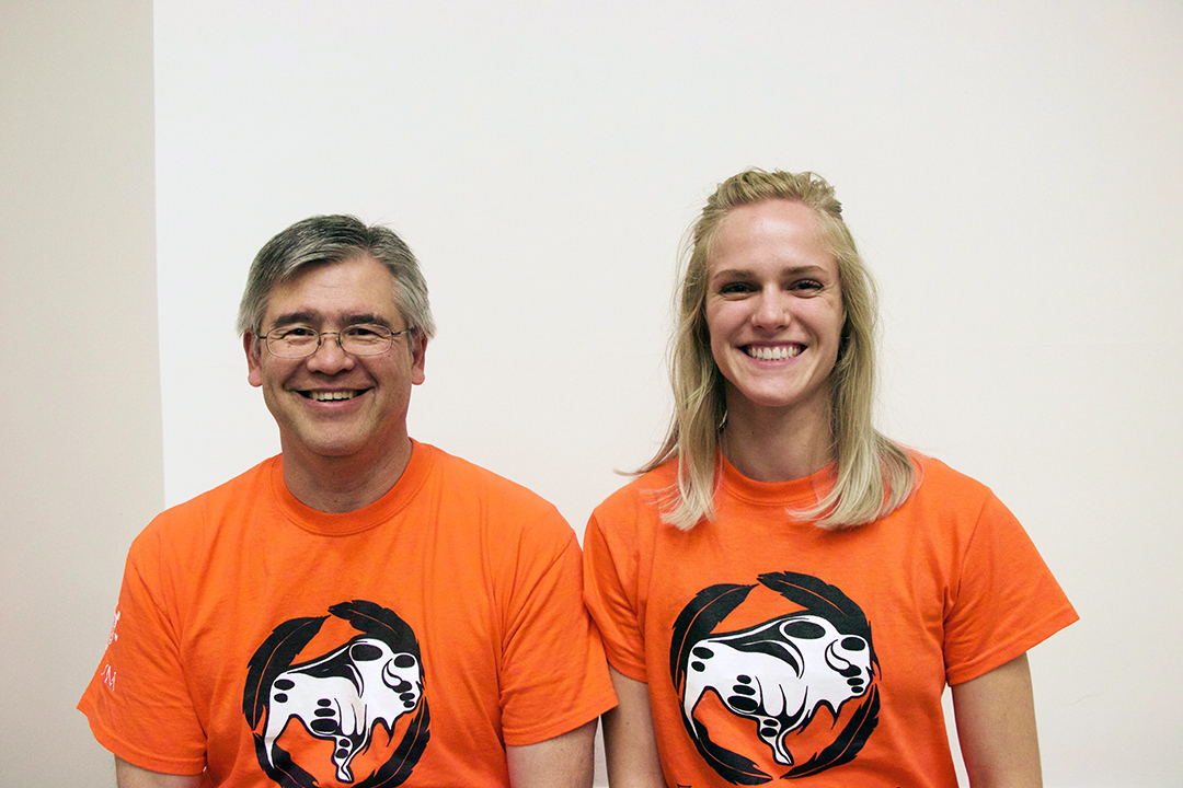 Dr. Andy Allen (left) and Katya Melnick wear the WCVM's orange shirt. 